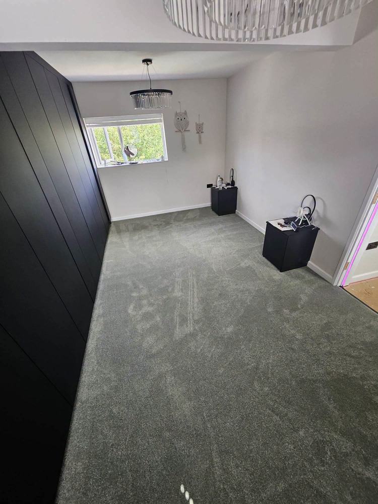 Grey bedroom carpet fitted against dark fitted wardrobes